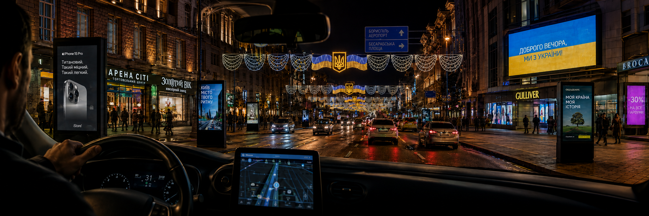 Digital advertising and information displays on a Kyiv street at night